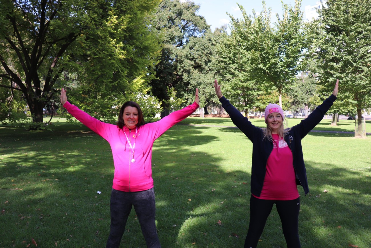 2 women wearing pink holding their arms up ready for the Mother's Day Classic