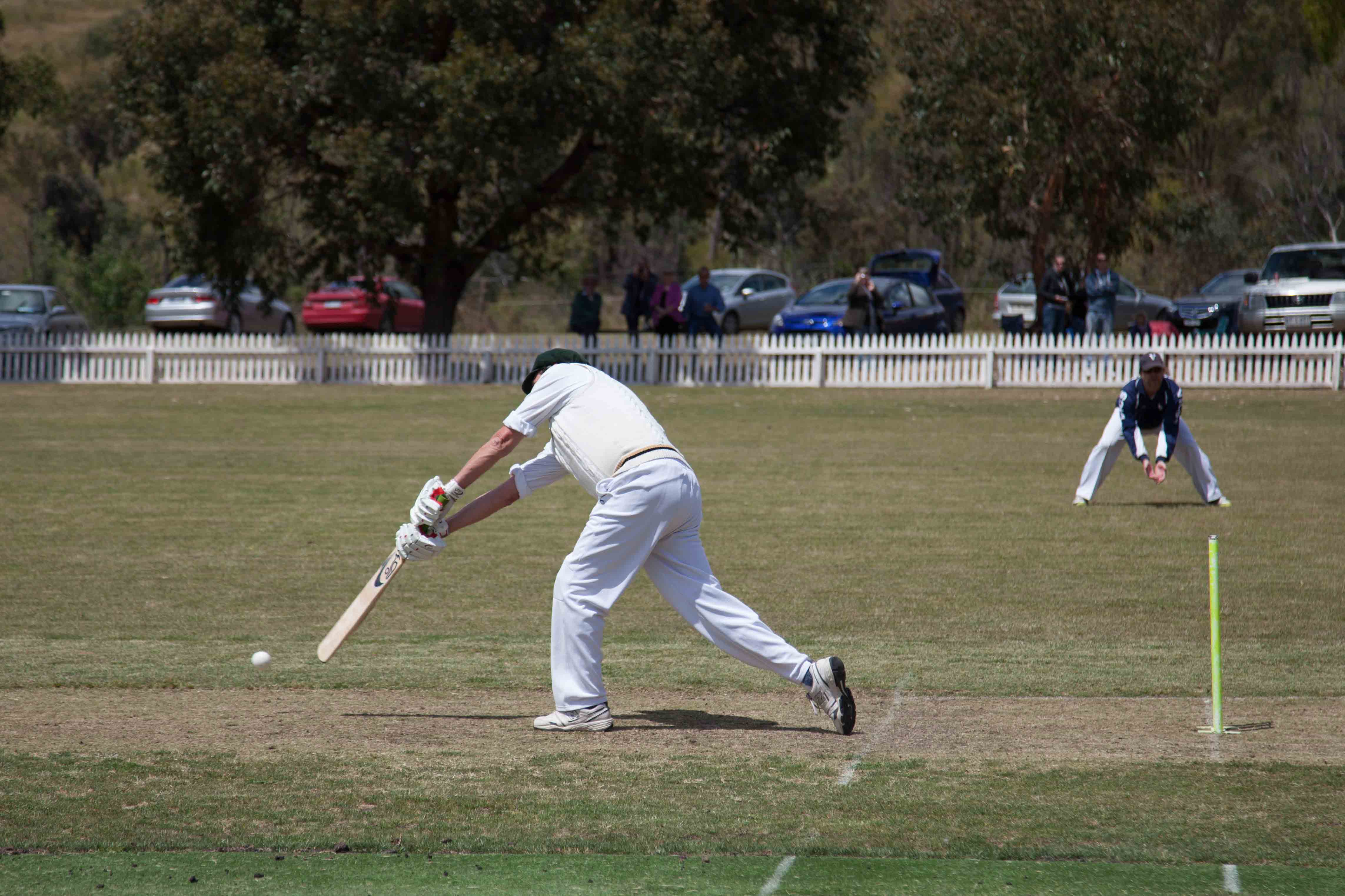 A cricket player hits a cricket ball.