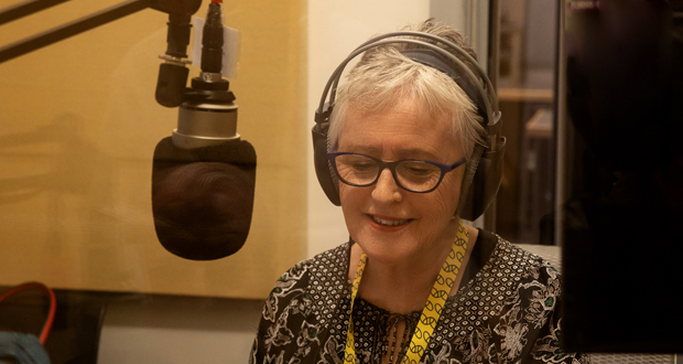 Woman in studio behind the microphone broadcasting