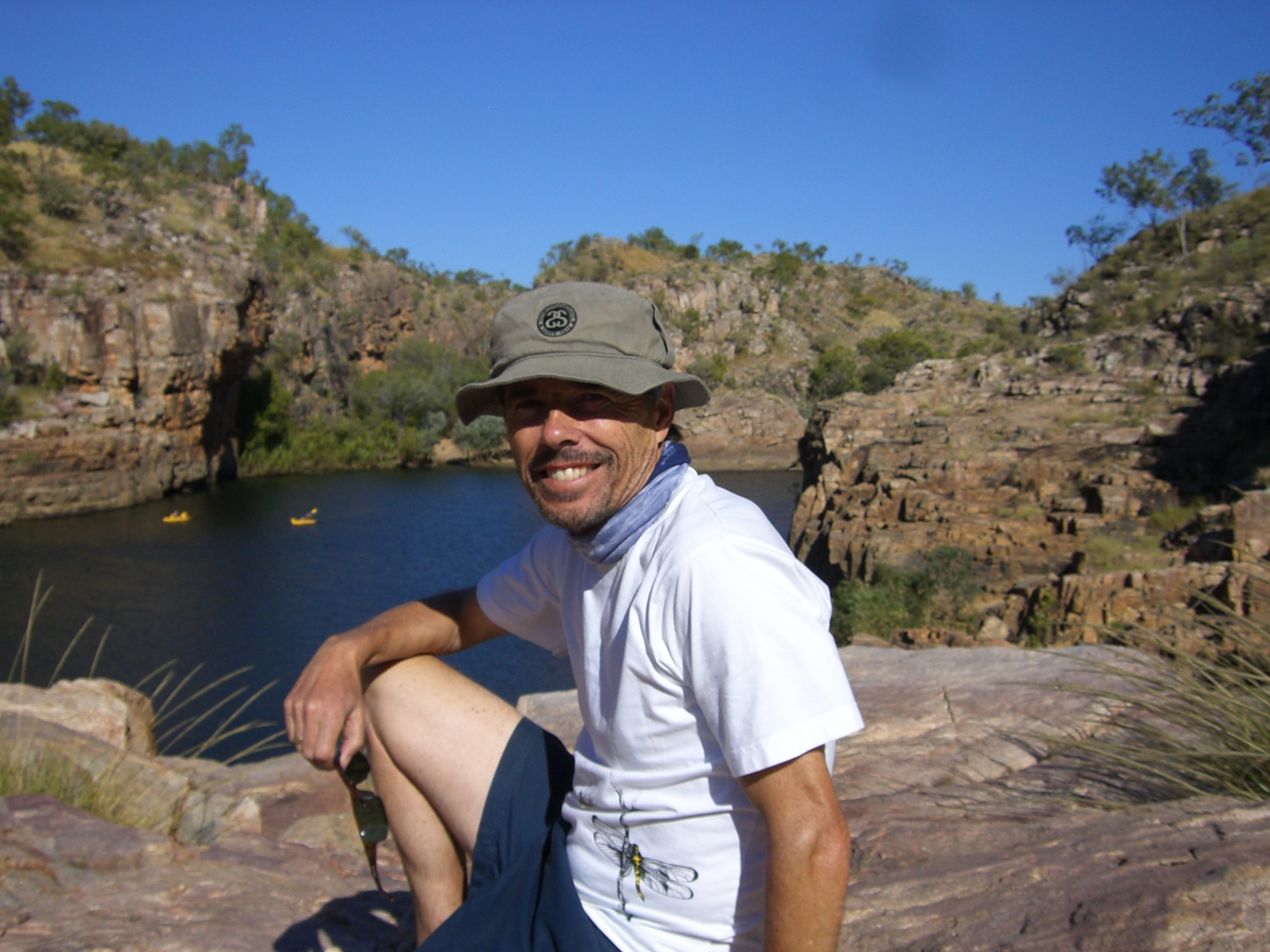 Nick-Green Nick Green headshot, he is outdoors, with a lake in the background smiling at the camera