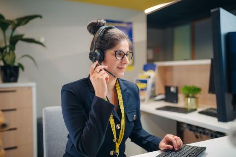 Anushka seated at a desk and is wearing a headset